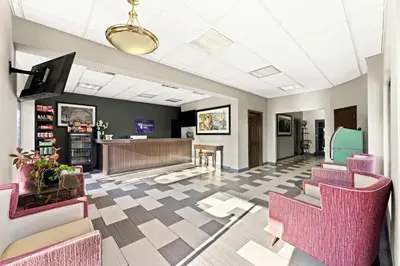 a waiting room with pink chairs and a counter at Knights Inn Montgomeryville in Montgomeryville