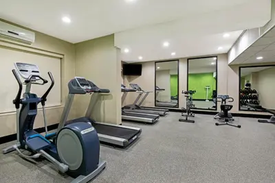 a gym with a row of treadms and cardio machines at La Quinta by Wyndham New Cumberland - Harrisburg in New Cumberland