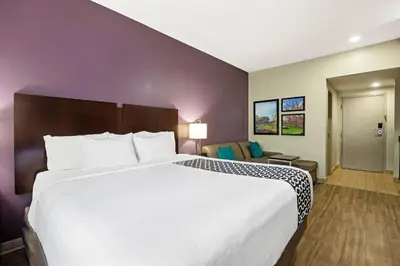 a large white bed in a hotel room at La Quinta by Wyndham New Cumberland - Harrisburg in New Cumberland