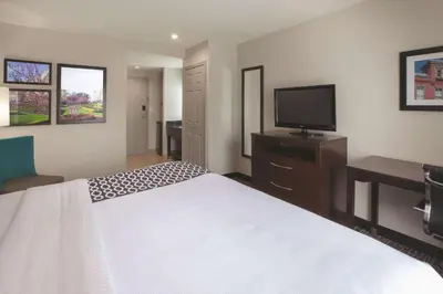 a hotel room with a bed and a flat screen tv at La Quinta by Wyndham New Cumberland - Harrisburg in New Cumberland