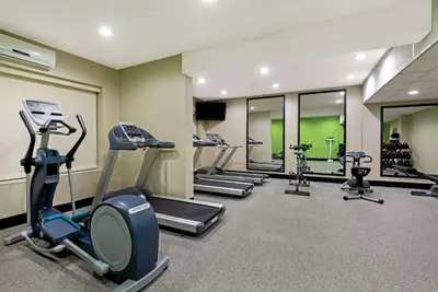 a gym with several exercise bikes and treadmills at La Quinta by Wyndham New Cumberland - Harrisburg in New Cumberland