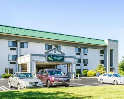 a hotel with two cars parked in a parking lot at Quality Inn Harrisburg - Hershey Area in Harrisburg