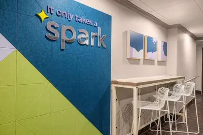 a wall with a sign that reads it only takes a spark at Spark by Hilton Clarks Summit in Clarks Summit