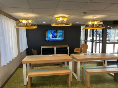 a conference room with two tables and a tv at Spark by Hilton Clarks Summit in Clarks Summit