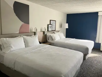 a hotel room with two beds and a blue wall at Spark by Hilton Clarks Summit in Clarks Summit