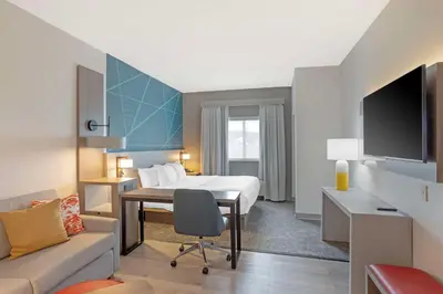 a hotel room with a bed and a desk at Comfort Suites Bloomsburg in Bloomsburg