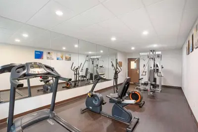 a gym with treadmills and ellipticals in a room at Comfort Suites Bloomsburg in Bloomsburg