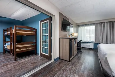 a hotel room with a bunk bed and a kitchen at Baymont by Wyndham Bartonsville Poconos in Bartonsville