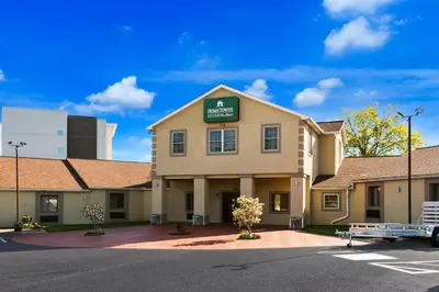 a front view of a hotel with a parking lot at HomeTowne Studios by Red Roof Denver, PA in Denver
