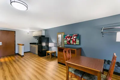 a living room with a table and a kitchen at HomeTowne Studios by Red Roof Denver, PA in Denver