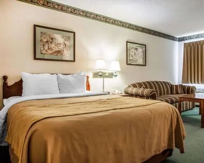 a hotel room with a bed and a chair at Quality Inn Midway in Bethel
