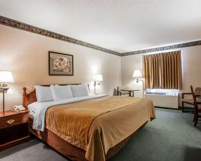 a hotel room with a bed and a table and chairs at Quality Inn Midway in Bethel