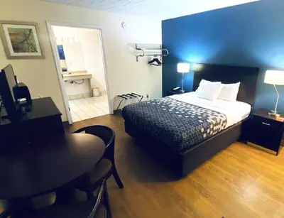 a hotel room with a bed and a table and a desk at Travelodge by Wyndham Shamokin Dam/Selinsgrove in Shamokin Dam