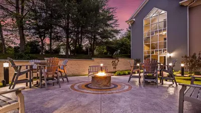 a patio with a table and chairs and a fire pit at Inn at Mendehall in Mendenhall