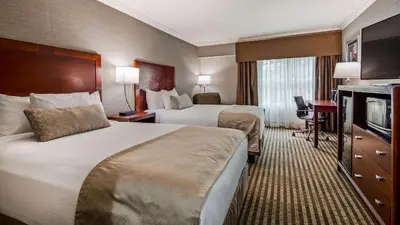 a hotel room with two beds and a television at Inn at Mendehall in Mendenhall