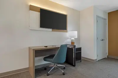 a room with a desk and a chair and a television at Comfort Suites Lewisburg near University in Lewisburg