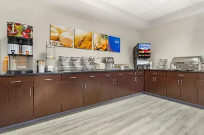 a kitchen with wooden cabinets and a coffee shop at Comfort Suites Lewisburg near University in Lewisburg