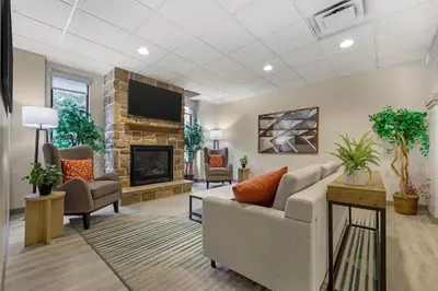 a waiting room with a couch and a fireplace at Comfort Suites Lewisburg near University in Lewisburg