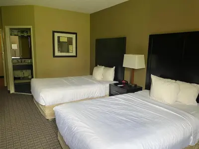 a hotel room with two beds with white sheets at SureStay Plus by Best Western Jonestown Lebanon Valley in Jonestown
