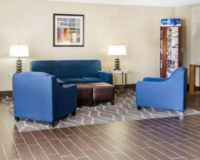 a living room with two blue chairs and a couch at SureStay Plus by Best Western Jonestown Lebanon Valley in Jonestown