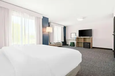 a hotel room with a white bed and a television at Spark By Hilton Exton in Exton