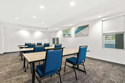 a conference room with tables and blue chairs at Spark By Hilton Exton in Exton