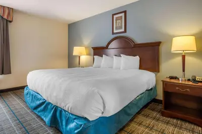 a large bed in a hotel room with two lamps at MainStay Suites Grantville - Hershey North in Grantville