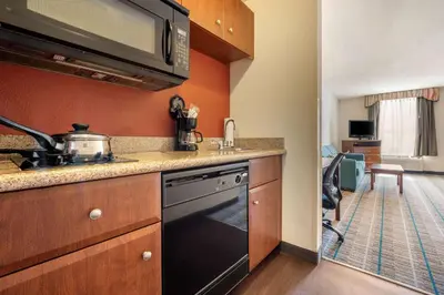 a small kitchen with a stove and a sink at MainStay Suites Grantville - Hershey North in Grantville