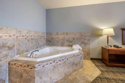 a bathroom with a bath tub in a room at MainStay Suites Grantville - Hershey North in Grantville