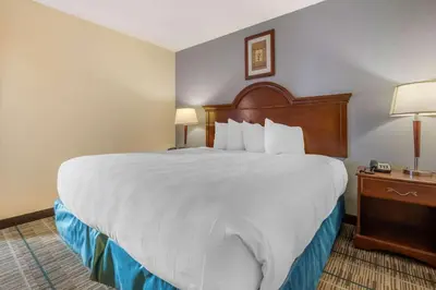 a large bed in a hotel room with two lamps at MainStay Suites Grantville - Hershey North in Grantville