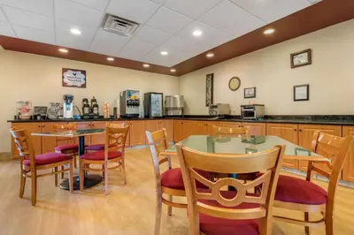 a restaurant with a table and chairs and a kitchen at MainStay Suites Grantville - Hershey North in Grantville