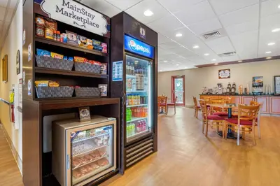 a grocery store with a refrigerator and a table with chairs at MainStay Suites Grantville - Hershey North in Grantville