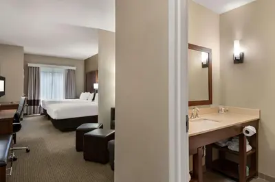a hotel room with a bed and a bathroom at Comfort Suites Hummelstown - Hershey in Hummelstown