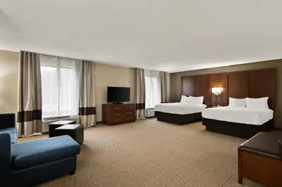 a hotel room with two beds and a flat screen tv at Comfort Suites Hummelstown - Hershey in Hummelstown