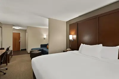 a hotel room with a large bed and a desk at Comfort Suites Hummelstown - Hershey in Hummelstown