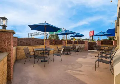 a patio with tables and chairs with blue umbrellas at Red Roof Inn Reading in Reading