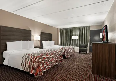 a hotel room with two beds and a television at Red Roof Inn Reading in Reading