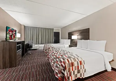a hotel room with two beds and a flat screen tv at Red Roof Inn Reading in Reading
