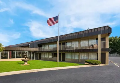 an american flag flies in front of a building at Red Roof Inn Reading in Reading