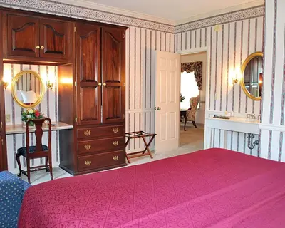 a bedroom with a pink bed and a dresser at Rodeway Inn & Suites Myerstown - Lebanon in Myerstown