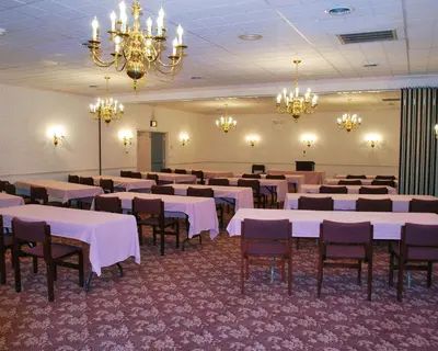 a banquet hall with white tables and chairs and chandeliers at Rodeway Inn & Suites Myerstown - Lebanon in Myerstown