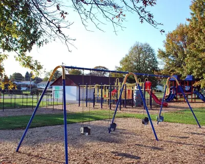 a playground in a park with swings at Rodeway Inn & Suites Myerstown - Lebanon in Myerstown
