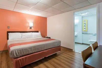 a bedroom with a bed with an orange wall at Motel 6-Frackville, PA in Frackville