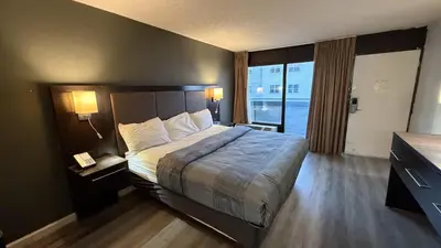 a hotel room with a bed and a large window at Wilkes-Barre Inn & Suites in Wilkes-Barre