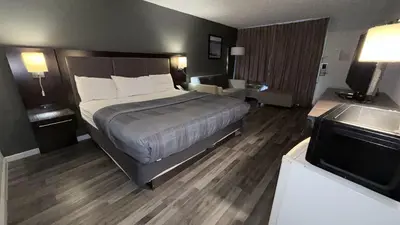 a hotel room with a bed and a flat screen tv at Wilkes-Barre Inn & Suites in Wilkes-Barre