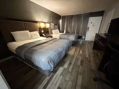 a hotel room with two beds and a television at Wilkes-Barre Inn & Suites in Wilkes-Barre