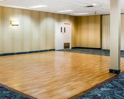 an empty gym with a wooden floor in a room at Wilkes-Barre Inn & Suites in Wilkes-Barre