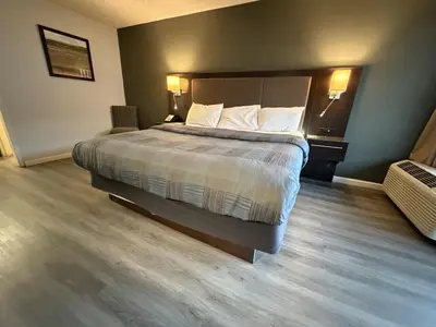 a hotel room with a bed with two pillows at Wilkes-Barre Inn & Suites in Wilkes-Barre