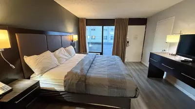 a hotel room with a bed and a desk and a television at Wilkes-Barre Inn & Suites in Wilkes-Barre