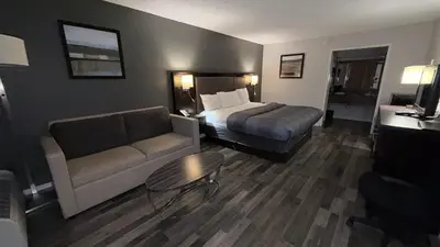 a hotel room with a bed and a couch at Wilkes-Barre Inn & Suites in Wilkes-Barre